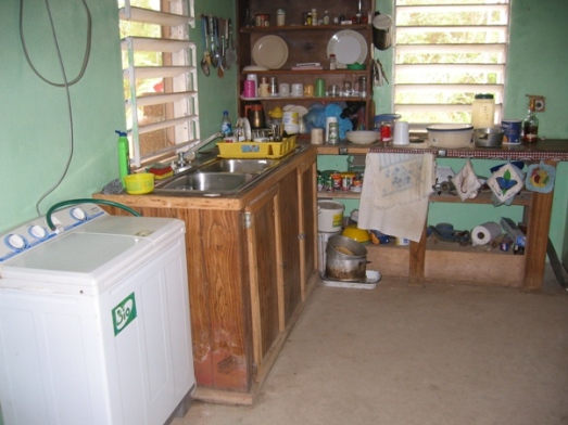 A bachelor's house in Toledo District.  He did the plumbing and electricity himself, but the washer and dryer, far left, come from Guatemala.  (Photo by Joan Fry)